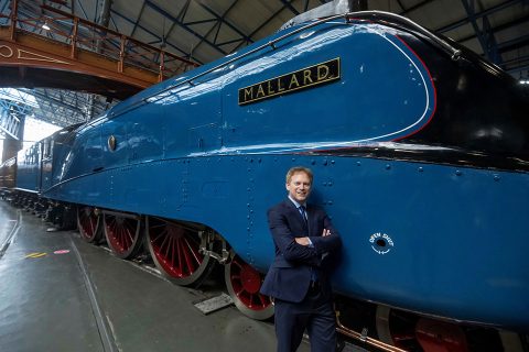 Politician Grant Shapps disrespectfully leans against Mallard with a cheesy grin on his face