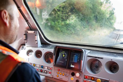 Train driver looks out from cab to the track ahead