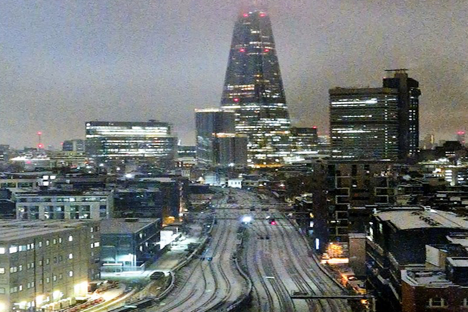 Nighttime shot of snowy London skyline showing railway tracks approaching London Bridge with The Shard on the skyline
