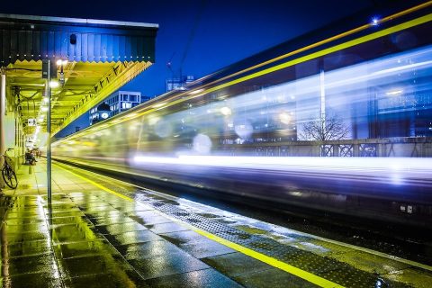 Train racing through Cardiff Central station at night