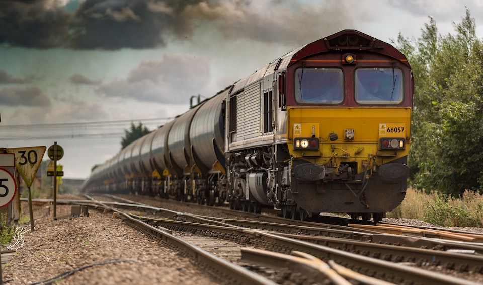 A ground level shot of an approaching class 66 diesel hauling a heavy load of tankers