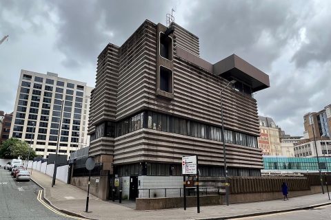 Street level view of Birmingham signal box, a Brutalist 1960s building with corrugated concrete features