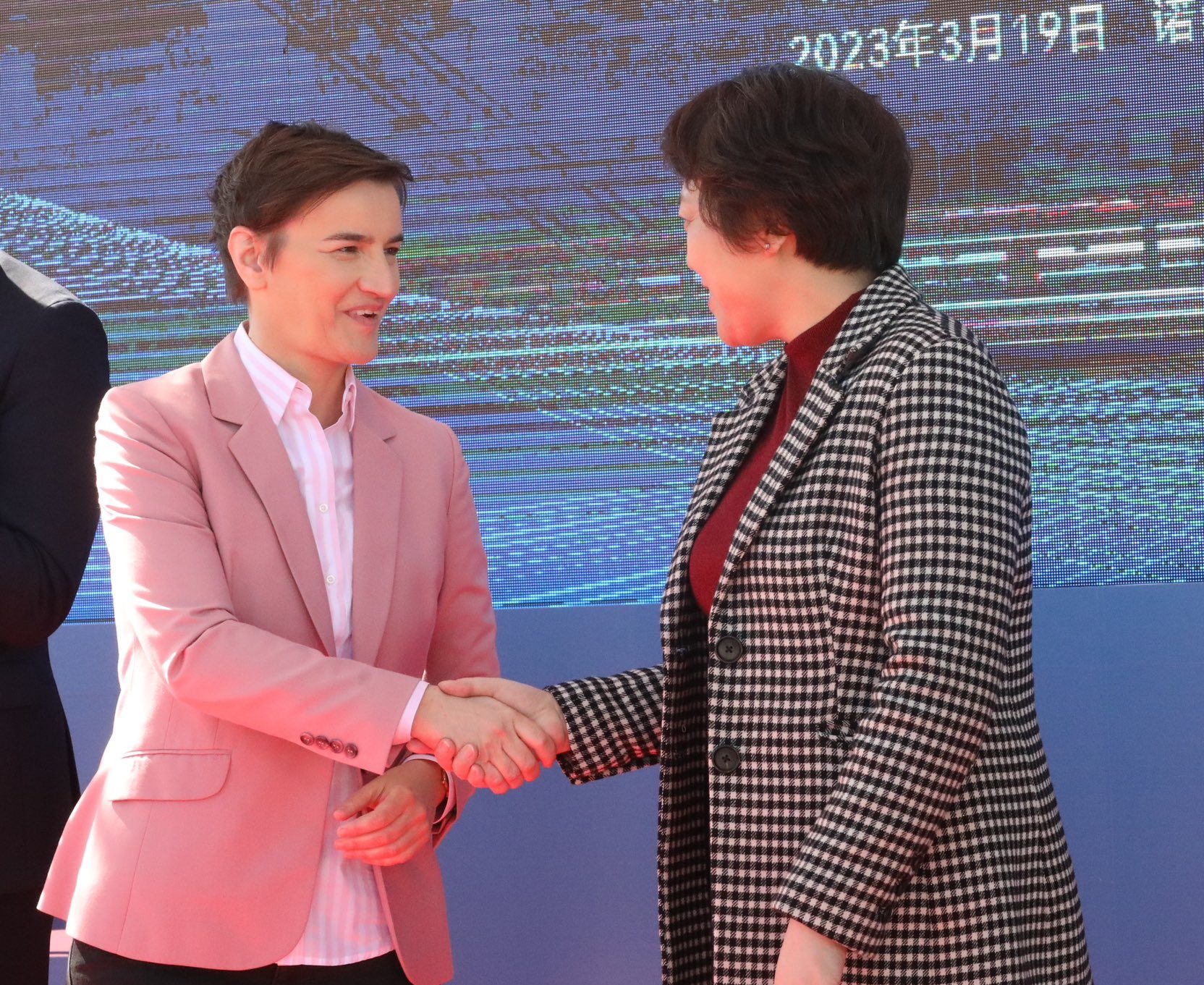 Serbian PM Ana Brnabic and Chinese Ambassador for Serbia Chen Bo shake hands at the anniversary ceremony