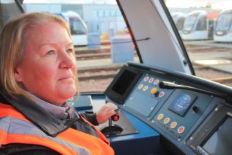 Female tram driver in orange jacket testing new tram in Edinburgh