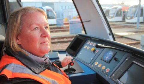 Female tram driver in orange jacket testing new tram in Edinburgh