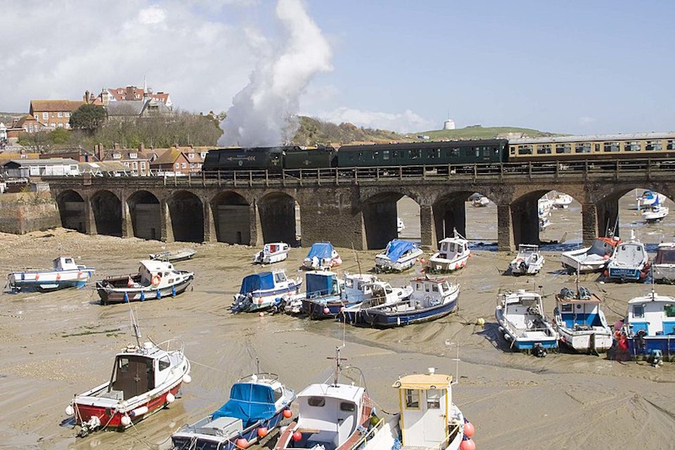 Steam engine hauls train over the harbour bridge at Folkestone