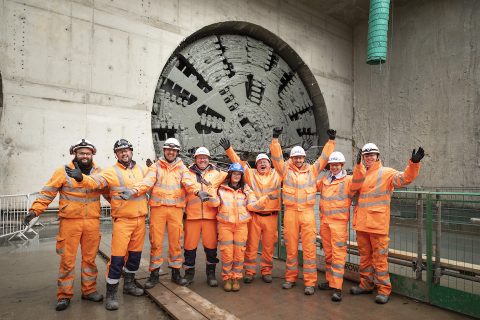In orange suits, the tunnelling team celebrate in front of the TBM in Warwickshire