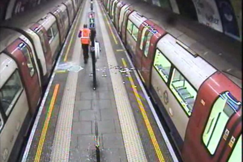 Image looking down the platform of trains stopped on the platform at Clapham Common station showing broken windows in the aftermath of the "unplanned evacuation"