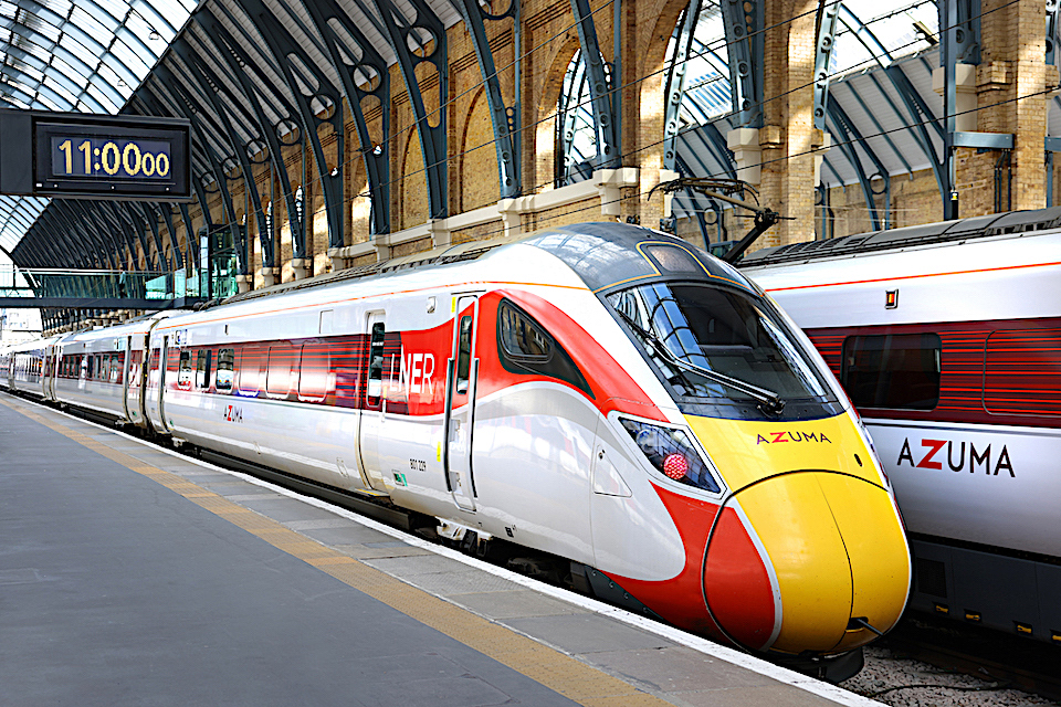LNER Azuma train standing at the platform in King's Cross with station clock showing 11am