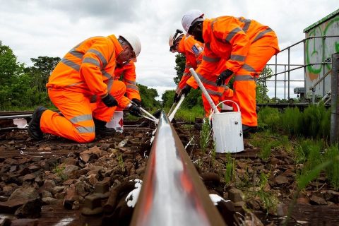 Rail level picture of engineers painting track white