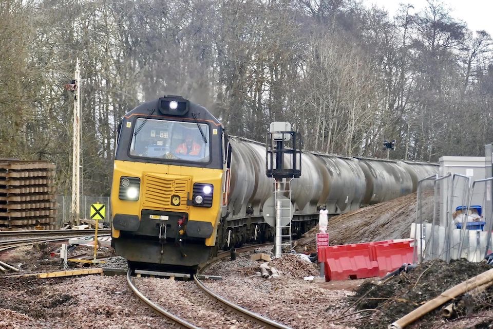 A Colas Rail UK class 70 heavy diesel hauls a train of tanks round a tight curve outside Perth in Scotland