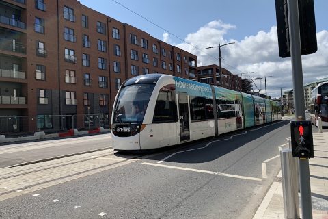 Edinburgh tram arrives at Port of Leith stop in bright sunshine