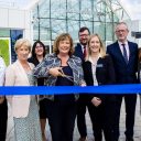 transport Minister Fiona Hyslop cuts the blue ribbon to symbolically open the redeveloped Motherwell station flanked by official guest, all smiles.