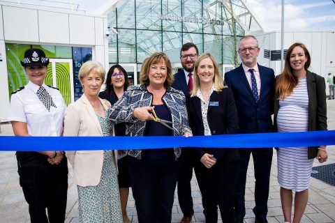 transport Minister Fiona Hyslop cuts the blue ribbon to symbolically open the redeveloped Motherwell station flanked by official guest, all smiles.