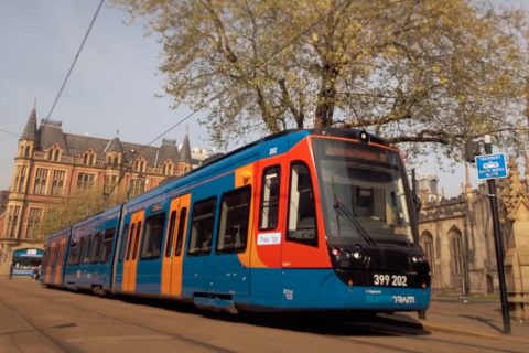 ground level three-quarter shot of Sheffield Supertram tram-train in front of Sheffield Cathedral