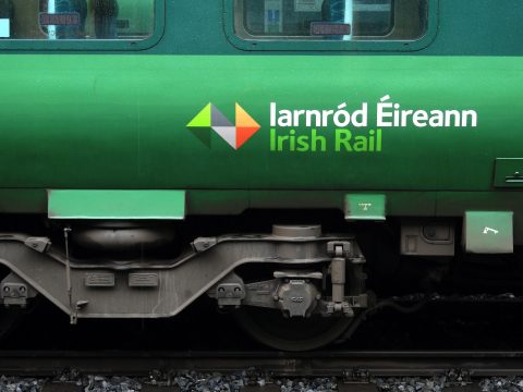 Side of an Irish Rail train showing the Irish Rail logo in English and Irish language.