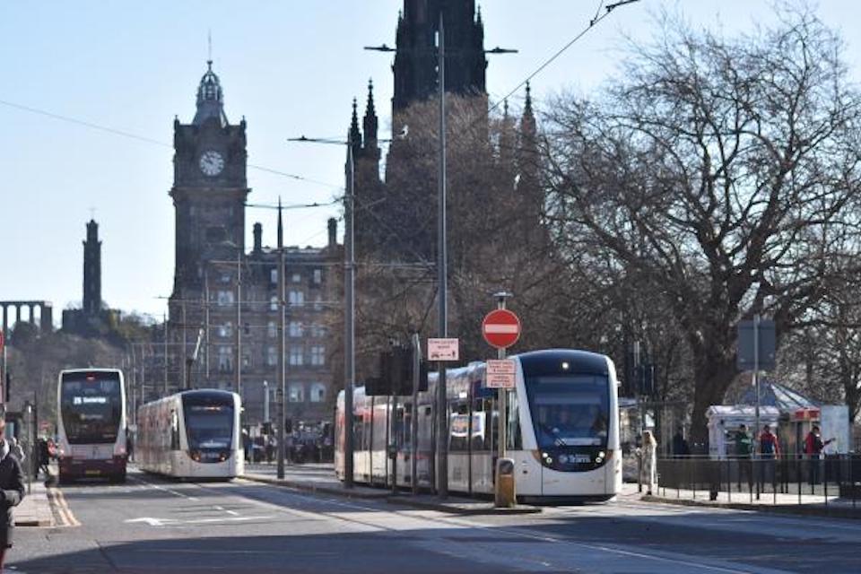 Edinburgh Tram on Princes Street with the Sir Walter Scott Monument and the North British clock in the background