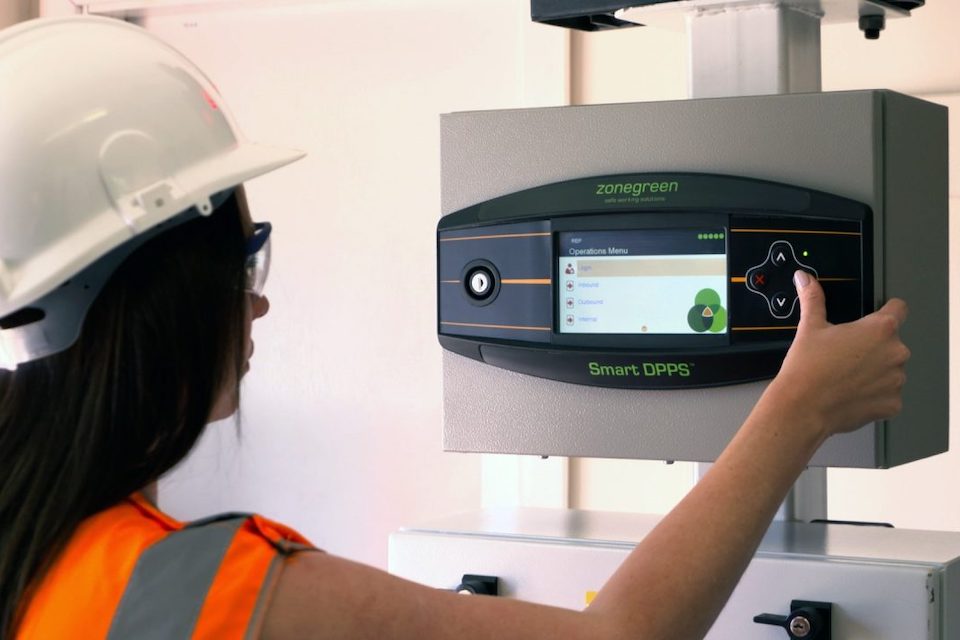 Female worker in safety gear operates the control panel of a Zonegreen system