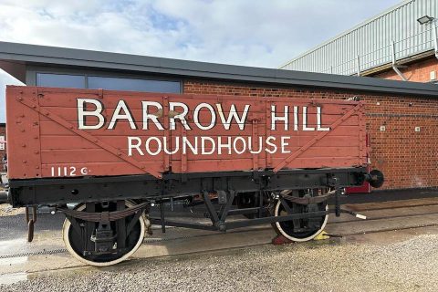 A picture of a historic goods wagon emblazoned with the words "Barrow Hill Roundhouse"