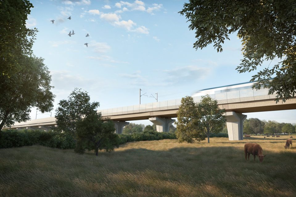 An HS2 train crossing a modern bridge countryside
