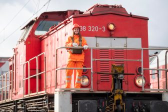 Woman rail worker in front of a locomotive